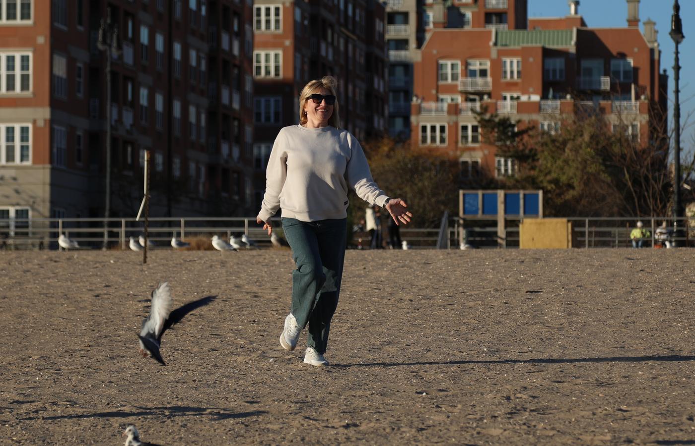 Woman walking near the brick beachfront buildings of Coney Island