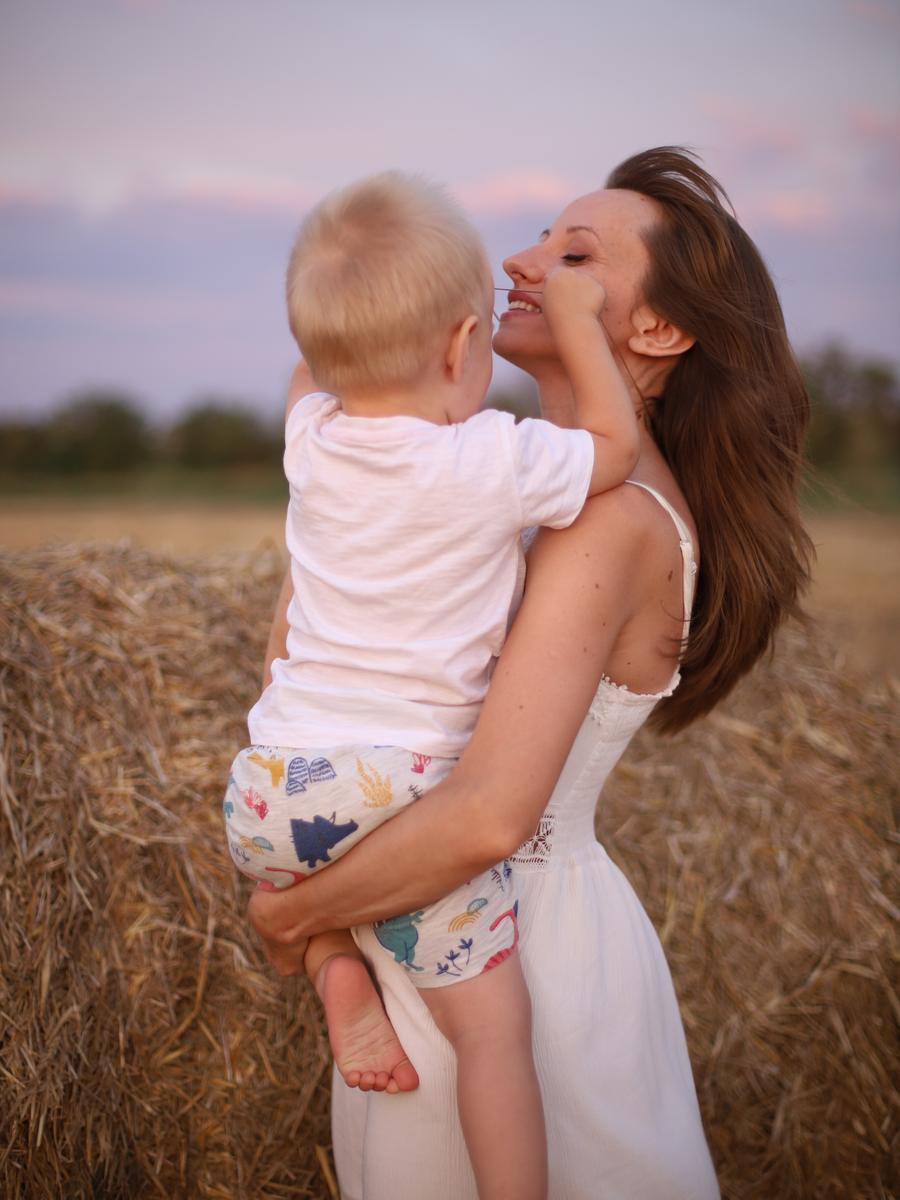 A mother lifting her child during a playful outdoor moment