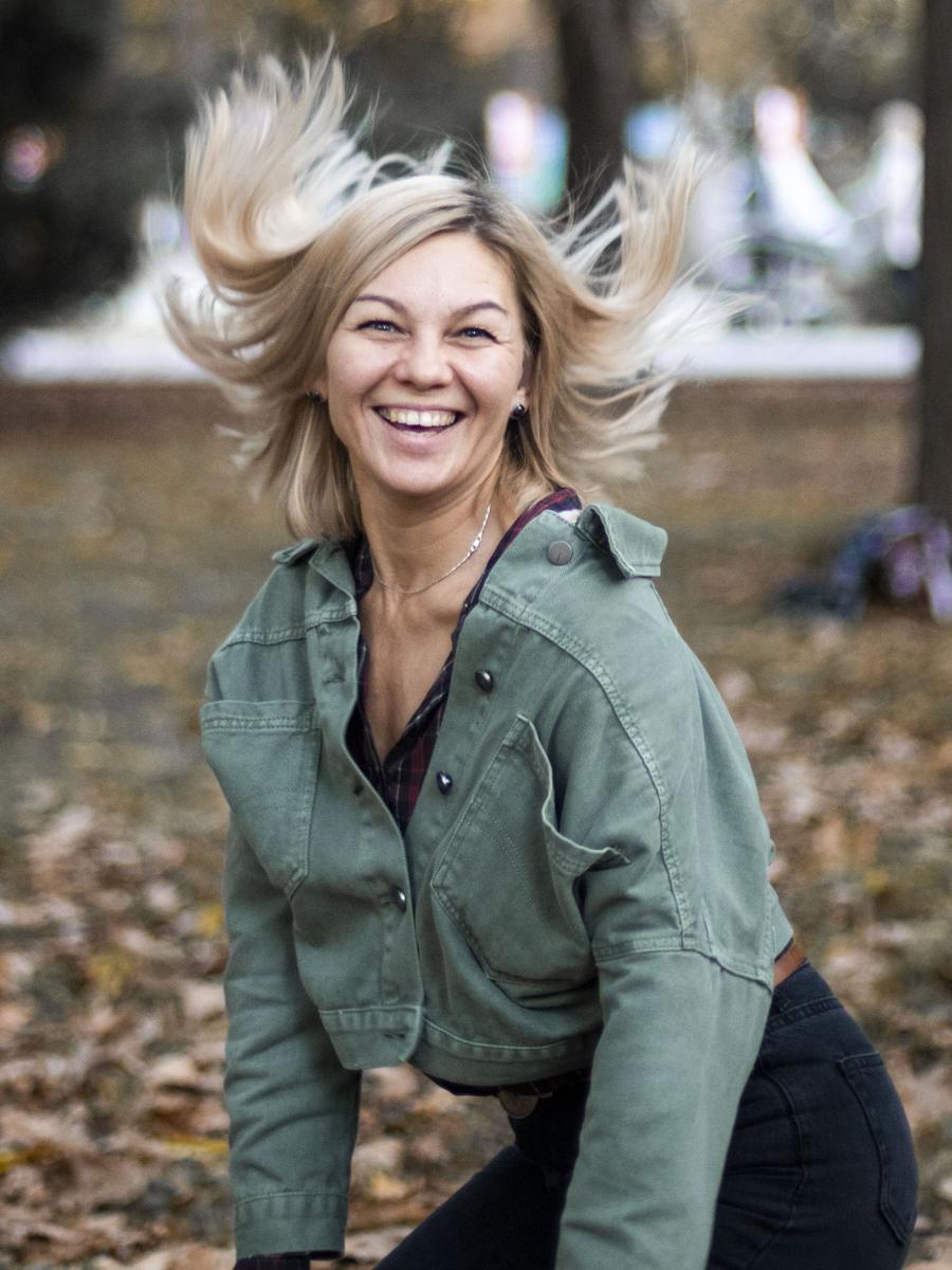 A joyful portrait of a woman laughing as her hair moves