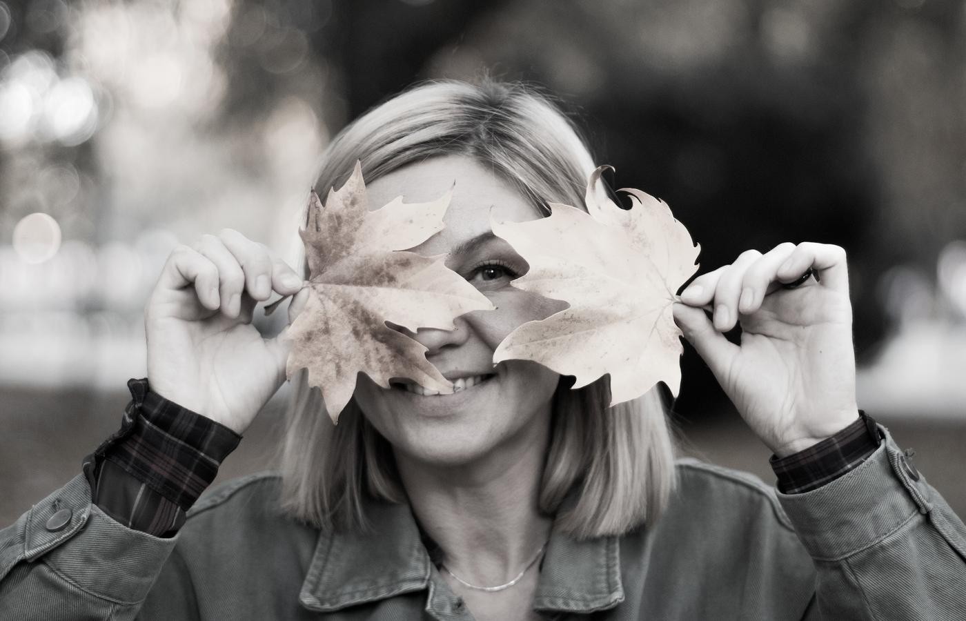 A playful black and white portrait made among fallen leaves
