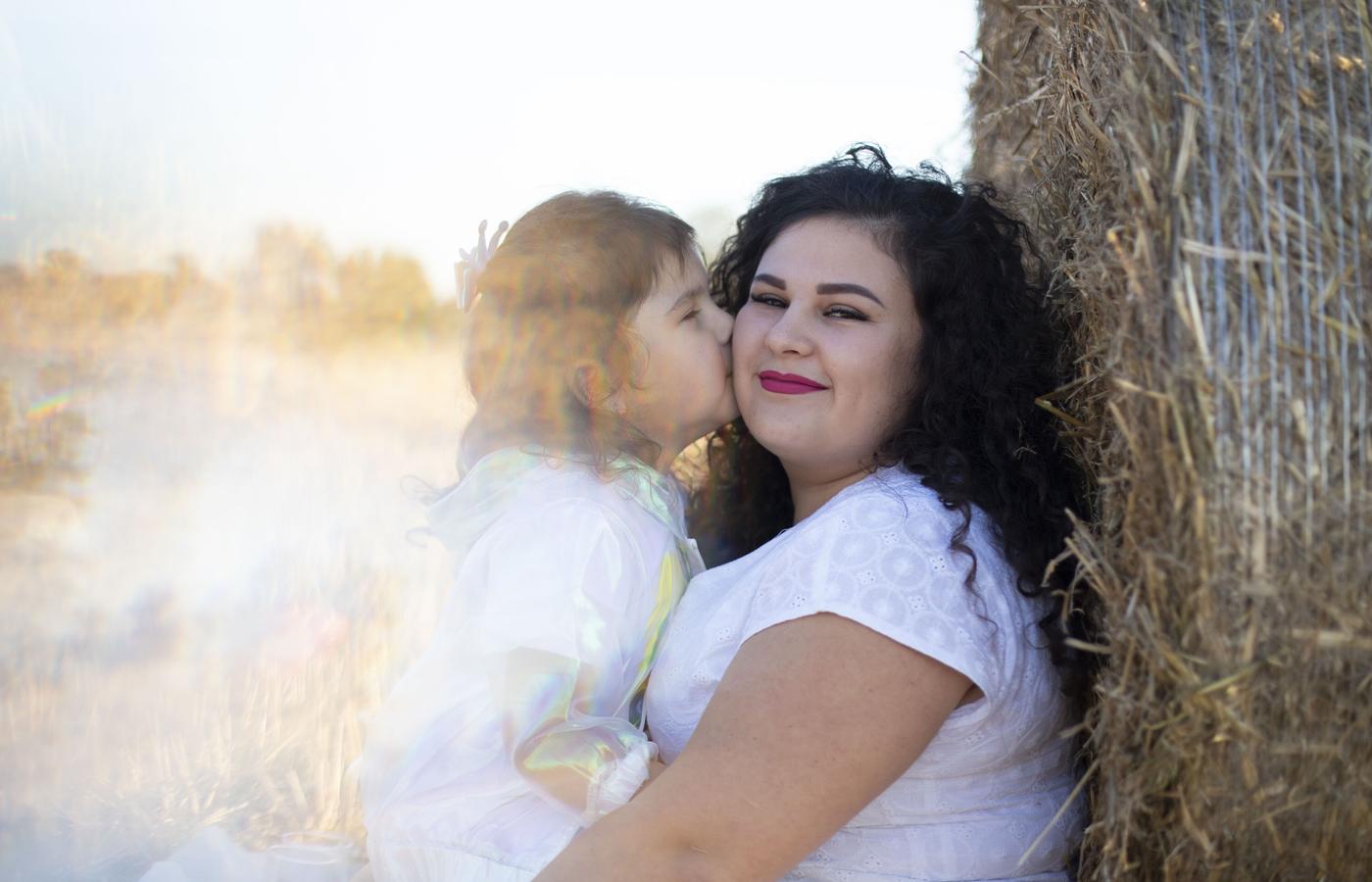A mother and daughters together in a softly lit outdoor portrait